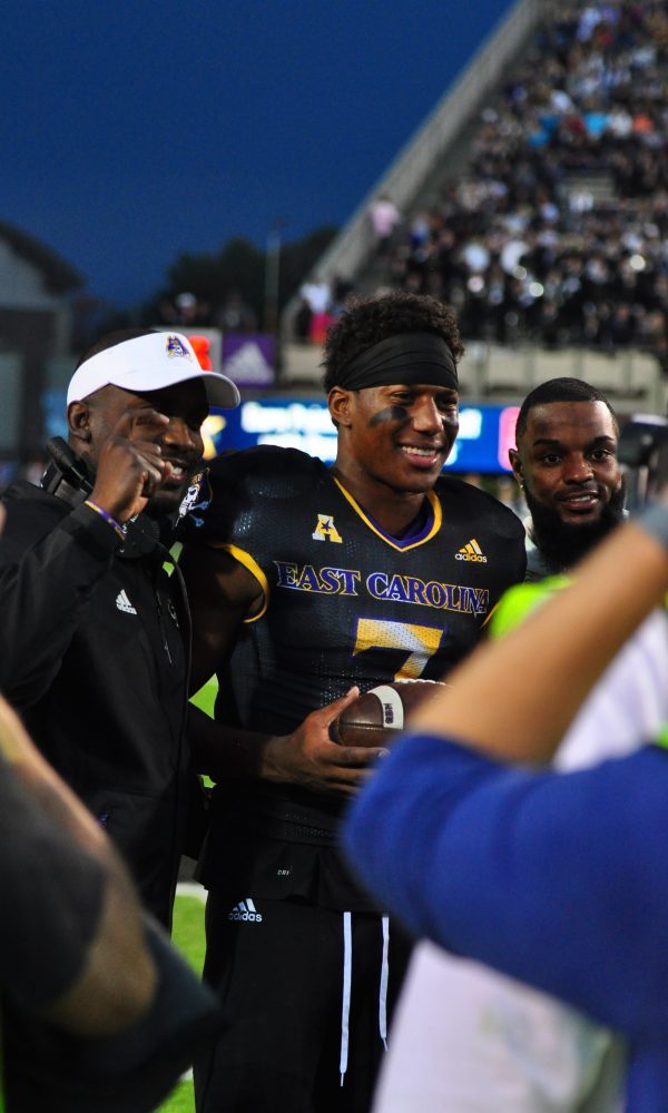 Zay Jones, with head coach Scottie Montgomery (left) and Justin Hardy (right) poses for pictures after being recognized for his record-breaking career during a break in action Saturday afternoon. (Bonesville Staff)