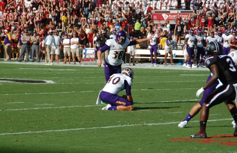 ECU holder Worth Gregory places the ball for a 43-yard field goal by ...