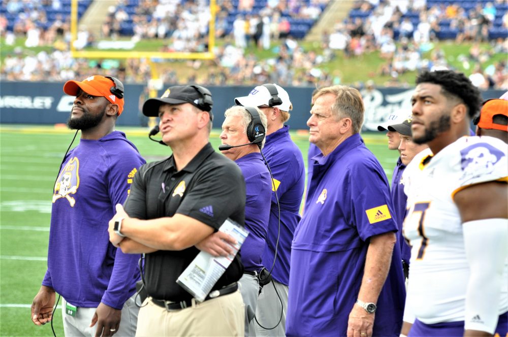 ECU coach Mike Houston watched action on the giant screen with Navy in the red zone