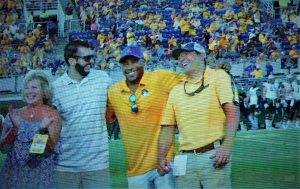 Harold Varner III (bright gold shirt), shown on the big screen, was welcomed back to his alma mater from the PGA Tour (Photo by Al Myatt)