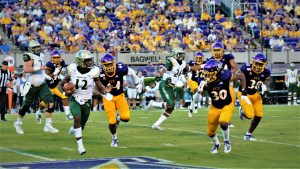 Pirates defenders Kendall Futrell (44), Gerard Stringer (30) and Bruce Bivens (38) move to contain William & Mary quarterback Hollis Mathis (Photo by Al Myatt)