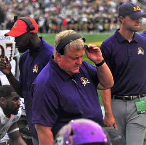 Pirates defensive coordinator Bob Trott talks on his headphones after a third-down stop by his unit
