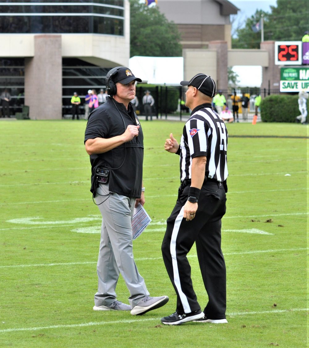 ECU coach Mike Houston talks to an official as an interception call is reviewed and subsequently overturned, keeping the ball in the Pirates' possession for a fourth-down punt. (Photo by Al Myatt)