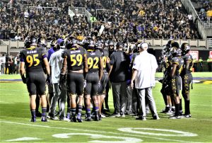 The Pirates huddle up during a timeout before making a third-down stop. (Photo by Al Myatt)